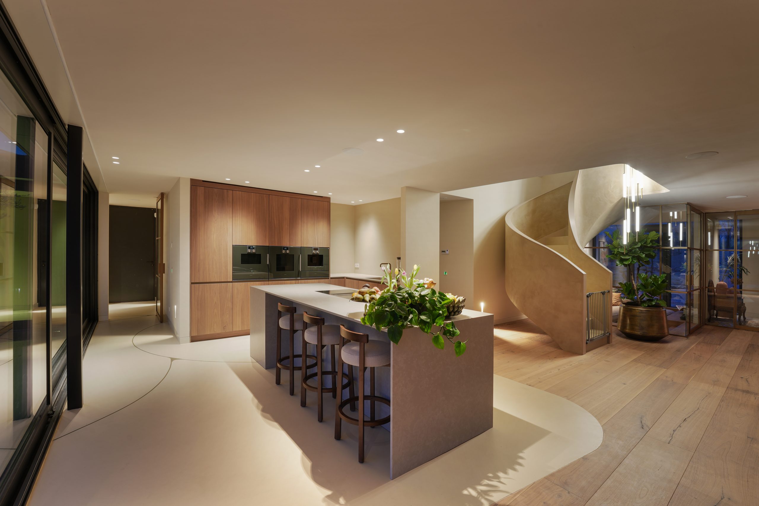 Maatwerk keuken met kookeiland en houten kastenwand in woning in Amstelveen.