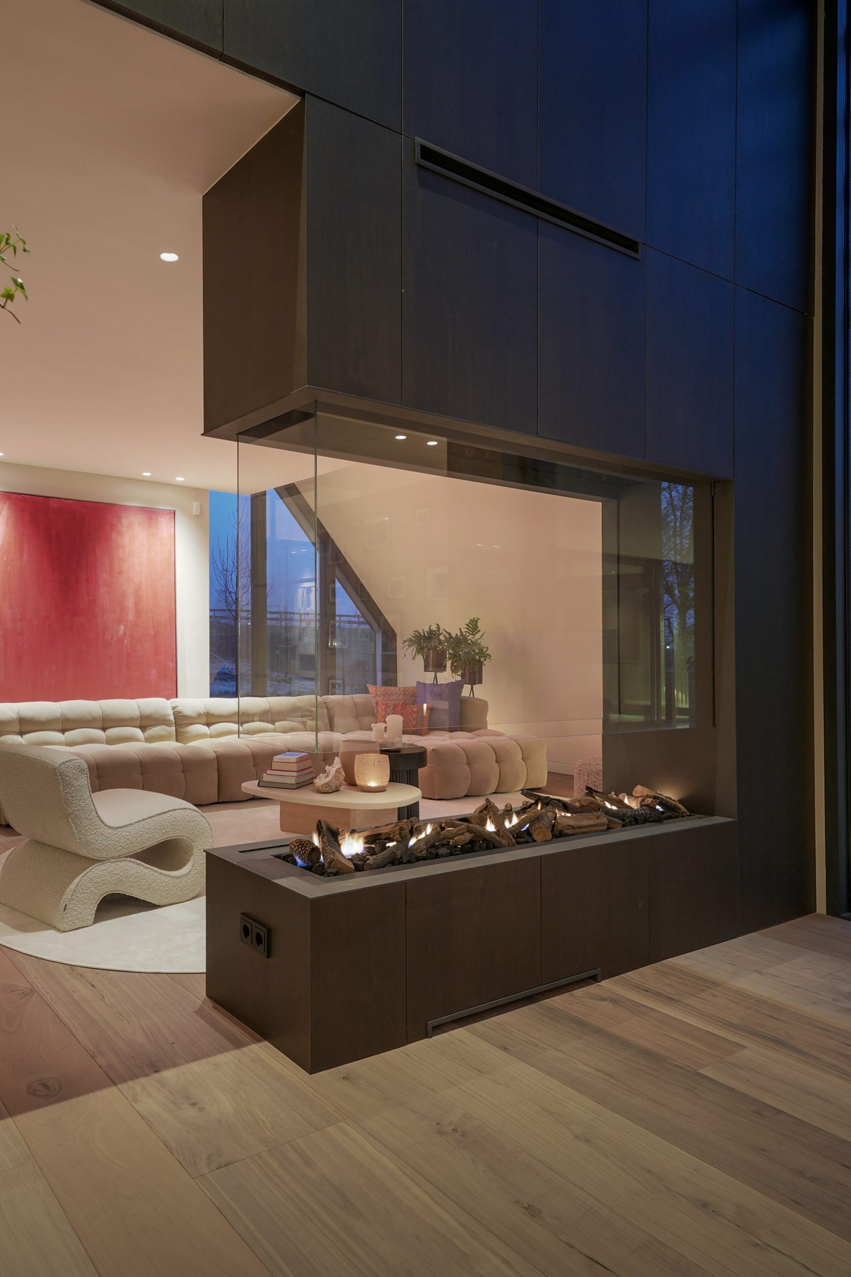 Maatwerk open haard met Shinnoki fineer kastenwand in woonkamer van woning.
