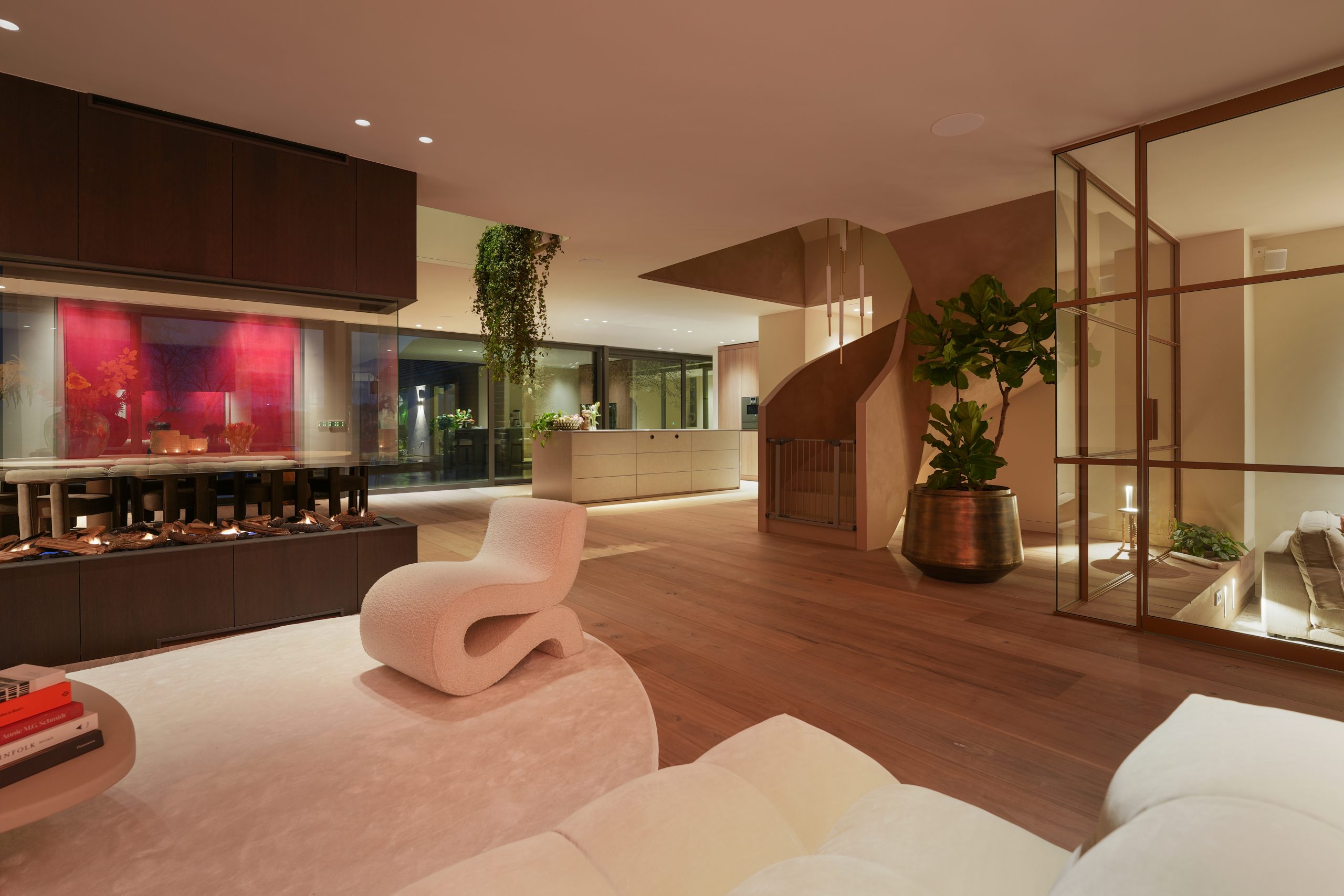 Maatwerk open haard roomdivider met doorkijk naar keuken met kookeiland in woning in Amstelveen.