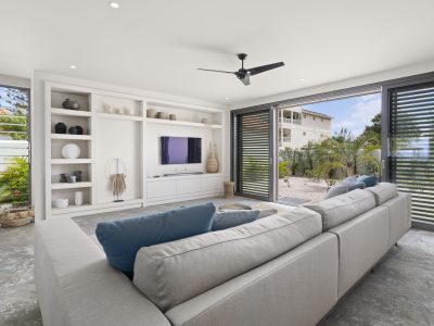 Maatwerk tv-meubel met open vakken en kastenwand in woonkamer van Villa Bonaire.