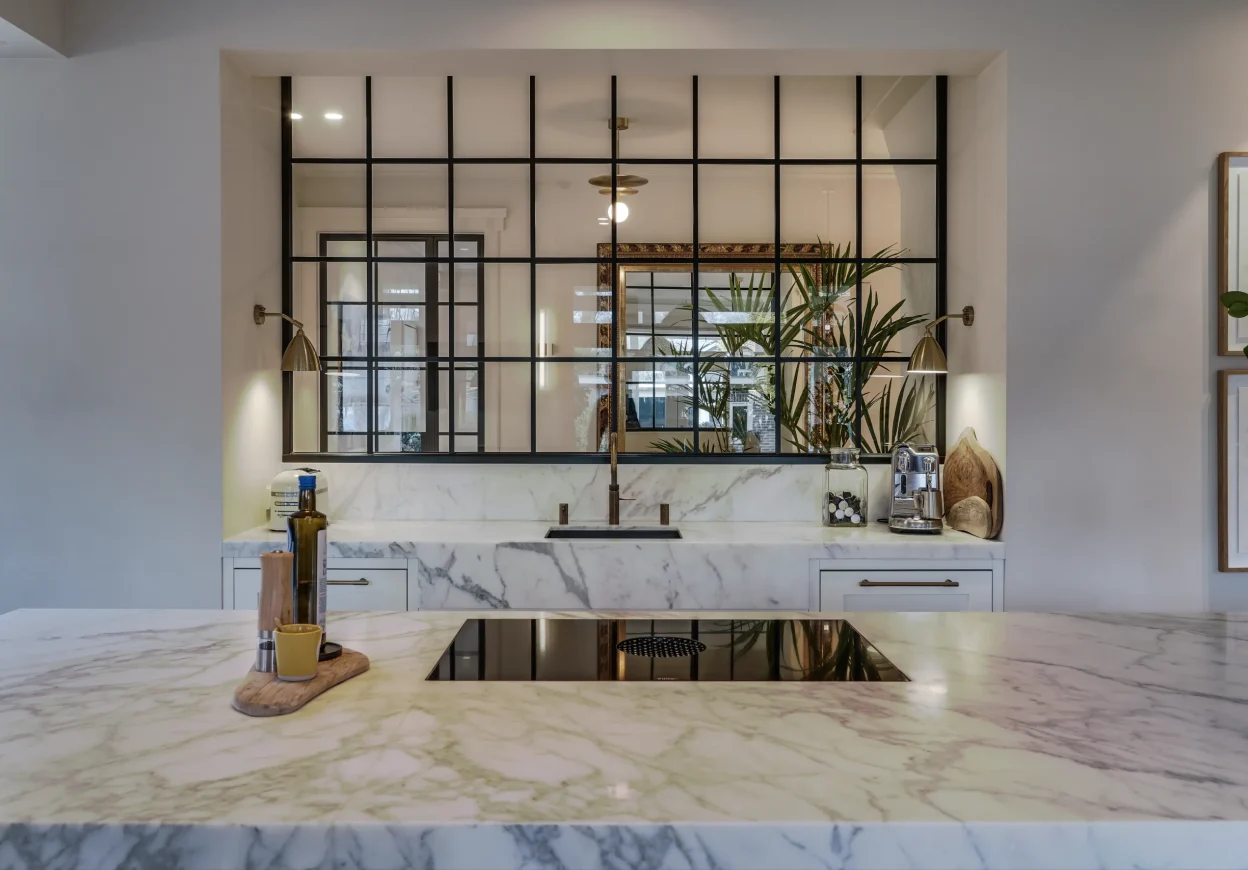 Maatwerk keuken met kookeiland en marmeren werkblad in woning Apeldoorn.